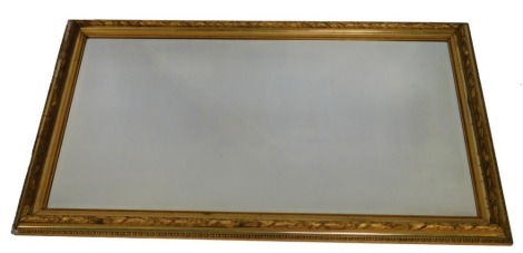 A French Argenture Empire style giltwood and gesso wall mirror, with a bevelled rectangular glass plate, 149cm x 88cm. (AF)