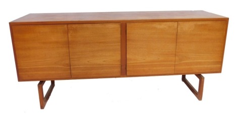 A mid century teak sideboard, with four doors, the third door opening to reveal six slides, raised on open rectangular supports, 71cm high, 160cm wide, 45cm deep.