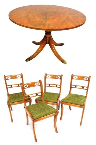 A Regency style yew wood tilt top circular dining table, raised on a turned column and four outswept legs, brass capped, 74cm high, 122cm wide, together with four single dining chairs.