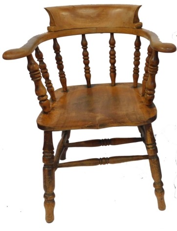 A Victorian oak and elm smoker's bow chair, raised on turned legs united by a double H framed stretcher, 63cm wide.