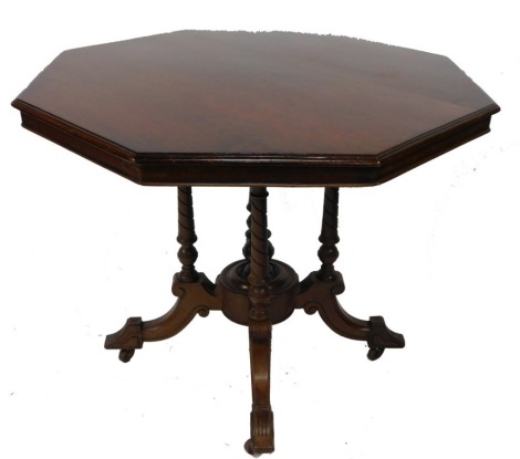 A Victorian mahogany octagonal window table, raised on turned supports, with a circular base section with outswept legs, on castors, 73cm high, 89cm wide.