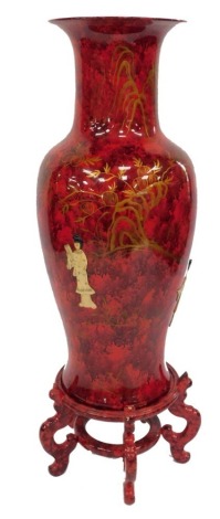 A Chinese pottery and shibayama vase, of baluster form, decorated with figures against a mottled red ground, raised on a similar mottled red circular stand, 117cm high.