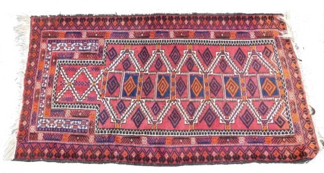 An Afghan red ground prayer rug, the mihrab filled with geometric motifs, within repeating geometric borders, 129cm x 76cm.