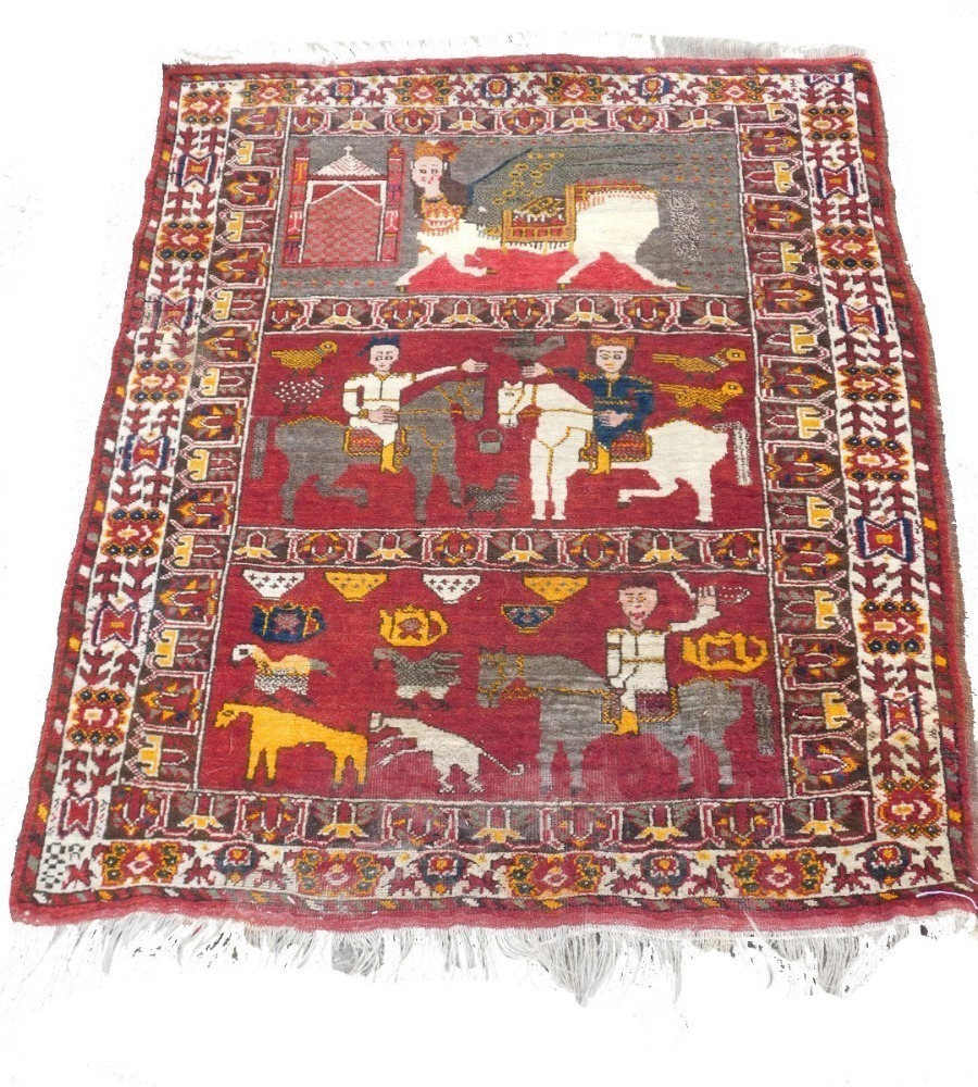 Persion Rug Figures A Persian Shiraz figural red ground rug, the upper panel with a winged ...