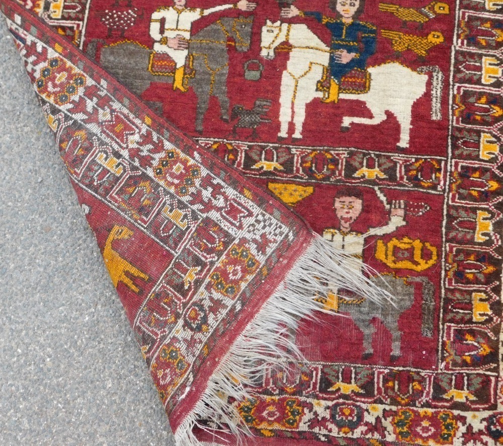 Persion Rug Figures A Persian Shiraz figural red ground rug, the upper panel with a winged ...