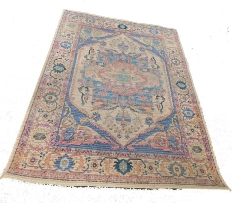 A Eurasian orange and cream ground rug, decorated with a central floral medallion, flowers and scrolling leaves, within repeating floral and foliate borders, 238cm x 189cm.