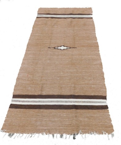 An Afghan Kilim rug, decorated with single geometric motif and brown and white stripe bands against a woven brown field, 283cm x 128cm.