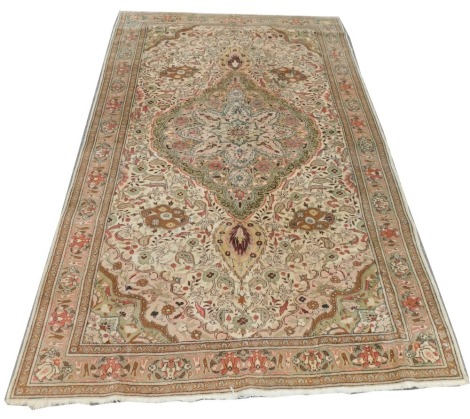 A Persian Qum cream ground rug, with a central medallion filled with flowers, the cream ground further filled with flowers, botehs and leaves, within repeating floral borders, 315cm x 203cm.