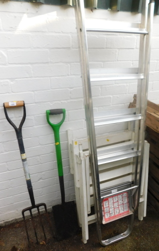 A metal step ladder, two folding garden chairs, spade and a fork.