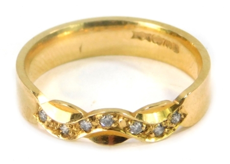 An 18ct gold dress ring, set with seven tiny diamonds, totalling 0.07ct, of wave design on a plain band, size O, 3.8g all in.