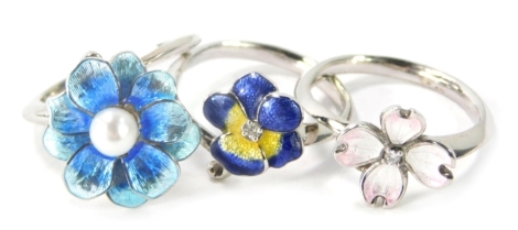 Three silver and enamel floral dress rings, comprising a blue floral dress ring with central cultured pearl, ring size M½, a cz and enamel poppy design dress ring, ring size O½, and a silver and pink enamel floral dress ring, ring size P, 10.7g all in. (3