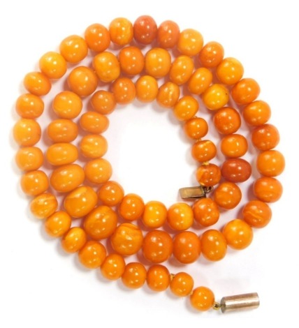 An imitation amber necklace, with graduated rough cut beads, on a silver gilt clasp, 52cm long.