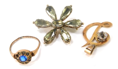 A small group of jewellery, comprising a dress ring, set with blue and white paste stones, rubbed and unmarked, a silver gilt and smoky quartz set star brooch, 3cm wide, unmarked, and a 9ct gold D pendant set with paste stone, and a dress ring. 8.7g all i