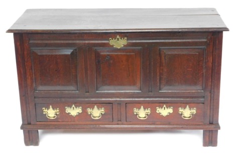 A 17thC oak mule chest, with lift top, and three fielded panels over two drawers to the front aspect, with solid brass back plate handles and escutcheons, raised on stiles, 78cm high, 132cm wide, 55cm deep.