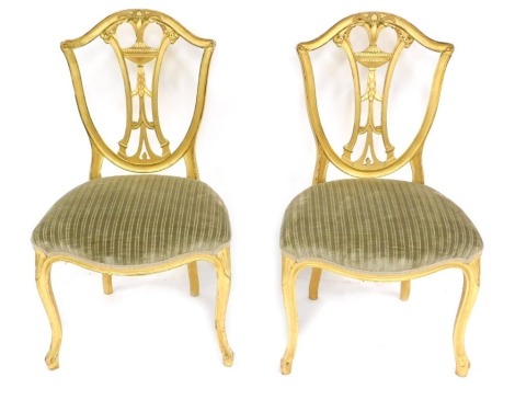 A pair of late 19thC Hepplewhite style Neoclassical giltwood salon chairs, with serpentine seats, 56cm wide.