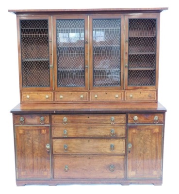 A Regency mahogany secretaire cabinet bookcase, with rosewood cross banding and ebony inlay, the upper part having a moulded cornice over four brass grill doors and drawers, the base with a secretaire drawer over two further drawers, enclosed by cupboards