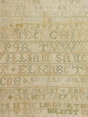 A Queen Anne alphabetic and numeric reverse sampler, marked Edward Bulnest, dated 1704, with capital E and B beneath crown, in colours, hand written verso Margaret Bullivant with paper label William Sancroft b.1617-1693 Archbishop of Canterbury 1678, Impr