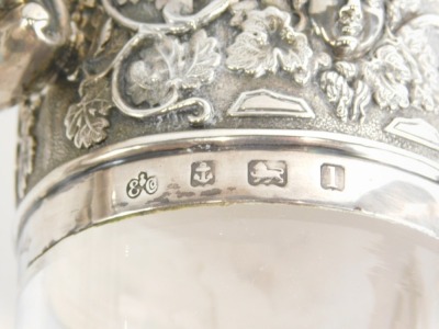 A matched pair of Edwardian silver, silver plated and cut glass claret jugs, by Elkington and Co, each with a lion and shield finial, angular thumb mould handle, and repousse decorated tops decorated with vine leaves and grapes with shaped spouts and bell - 3