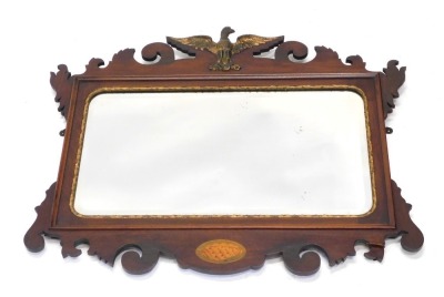 A 19thC mahogany framed fret mirror, surmounted by a gilded bird with wings out stretched, with a shell patera and shaped scroll frame, with gilt moulding and plain glass, 59cm high, 72cm wide.