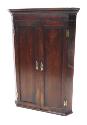 An 18thC oak hanging corner cupboard, the plain panelled doors revealing a fitted interior, set with shaped shells with moulded base, 103cm high, 71cm wide, 41cm deep.