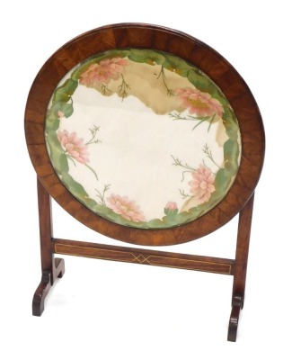 An early 20thC walnut tilt top table, with horizontal stretcher, with X shaped inlay and embroidered floral top, on scroll feet, when raised 76cm high, the top 57cm diameter.