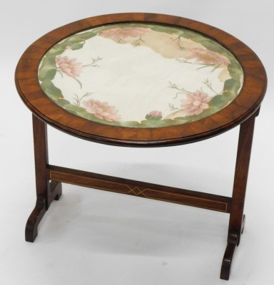 An early 20thC walnut tilt top table, with horizontal stretcher, with X shaped inlay and embroidered floral top, on scroll feet, when raised 76cm high, the top 57cm diameter. - 2