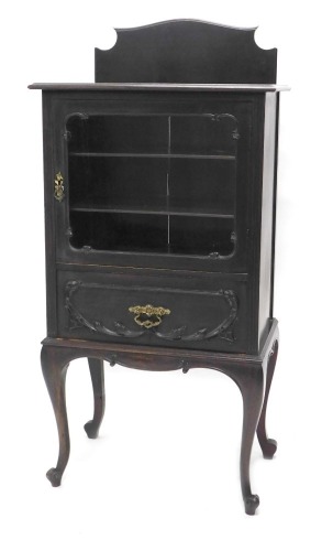 An Edwardian stained walnut music cabinet, the glazed door hinging to reveal articulated shelves above single drawer, on cabriole legs terminating in scroll feet, 128cm high, 60cm wide, 39cm deep.