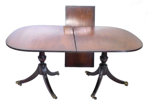 A twin pillar mahogany D end extending dining table, with one leaf, on turned legs terminating in brass hairy paw feet with castors, when closed 76cm high, 141cm wide, 108cm deep, with single leaf.