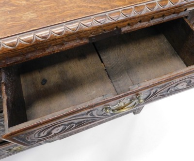 A Victorian oak sideboard, with part moulded top, raised above an arrangement of three central drawers flanked by two drawers and cupboards, each heavily carved with flowers and scrolls, on block stiles, 81cm high, 162cm wide, 46cm deep. - 2