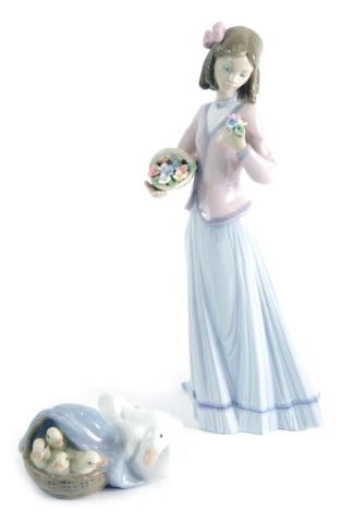 A Lladro figure, Innocence in Bloom, 07644, 22cm high and a further figure duck and ducklings. (2, each boxed)