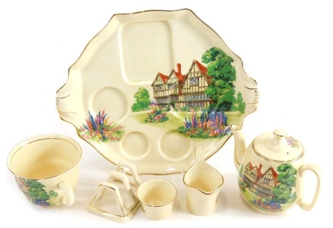 A Royal Winton breakfast tea set, comprising teapot, cup, toast rack, milk jug and sugar bowl on stand, transfer printed with houses and flowers, 23cm wide.