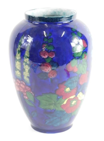 A 20thC pottery Adderley Limited Hollyhock pattern vase, typically decorated with flowers on an opalescent blue ground, printed marks beneath, 26cm high.