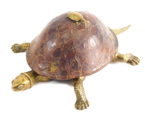 An unusual leather and brass desk smoking stand, in the form of a tortoise, the hinged back revealing removable cups, on shaped feet with realistic head and tail, unmarked, 28cm high.