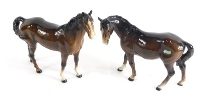 A Beswick pottery horse, in brown and white colour way, head lowered, 19cm high, and another, printed marks beneath. (2) (AF)