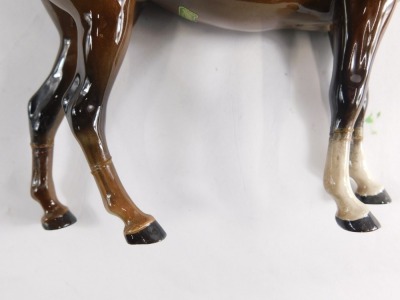 A Beswick pottery horse, in brown and white colour way, head lowered, 19cm high, and another, printed marks beneath. (2) (AF) - 3