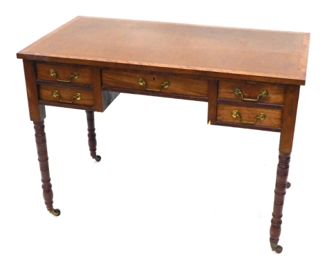 An Edwardian mahogany desk, with leather top raised above a single long drawer flanked by four short drawers, on turned legs terminating in casters, 75cm high, 104cm wide, 58cm deep.