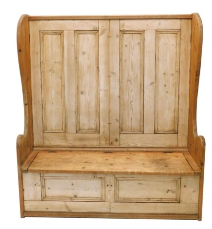 A reclaimed pine tavern bench settle, with panelled back, shaped sides, log box seat and panelled front, 171cm high, 146cm wide, 51cm deep.