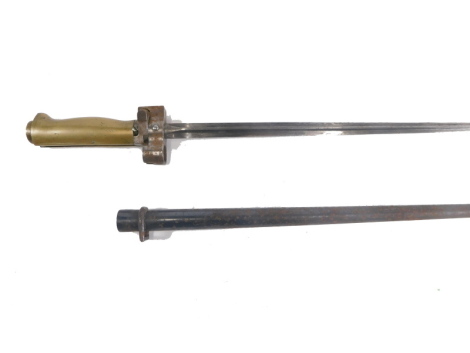 A 20thC cylindrical bayonet and scabbard, with unmarked shaped blade and brass handle, with compressed circular pommel, 64cm long.