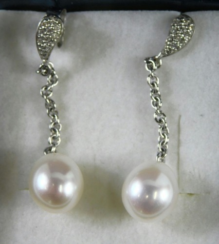 A pair of 18ct white gold diamond and pearl drop earrings, the waved stud with chain link, with a cultured pearl, white metal stamped 750, on a single pin back with butterfly back, 1.3g all in, boxed.