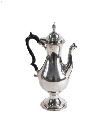 A George III plain silver coffee pot, by Hester Bateman, with urn finial, domed lid, ebonised thumb mould ear shaped handle, bead lined spout, plain pear shaped body, on inverted stem and circular bead lined foot, London 1787, 37cm high, 26.6oz all in.