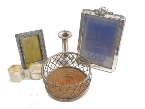 A George V silver napkin ring, of hexagonal form, initialled JBDB, London 1936, 5cm wide, a further silver napkin ring, squat weighted candlestick, plated coaster, and two photograph frames.