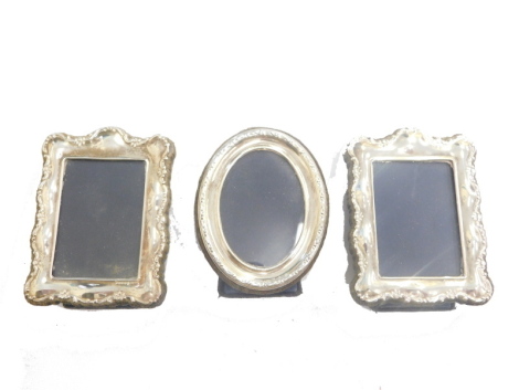 A pair of Elizabeth II miniature silver fronted photograph frames, each with velvet lined easel backs, Sheffield 1991, each 7cm x 6cm, and a further oval photograph frame. (3)