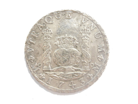 A silver coloured 8 Reales, with inscription BNUNM 1743 Philip.