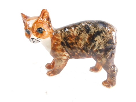 A 20thC Isle of Man Rushton Pottery figure of a Manx kitten, in mottled brown colours, marked beneath, 7cm high.