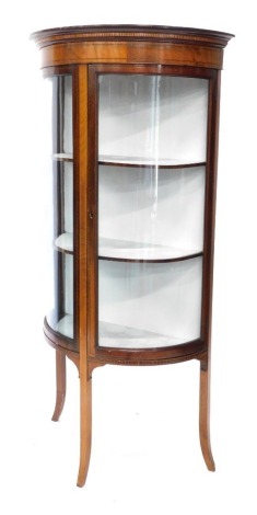 An Edwardian mahogany and boxwood strung Sheraton style bow fronted display cabinet, the double doors revealing fixed shelves, on sabre legs, 148cm high, 69cm wide, 38cm deep.