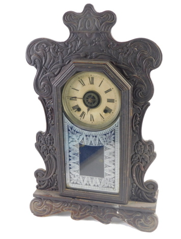 A late 19thC American oak Ansonia gingerbread mantel clock, with 13cm diameter Roman numeric dial, fitted in a heavily carved case, with glazed front, eight day movement, with pendulum.