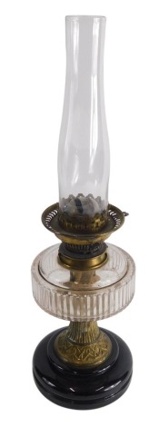 An early 20thC oil lamp, with clear glass reservoir and plain glass funnel, 22cm high.