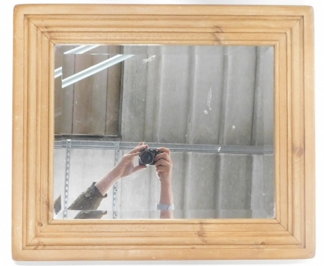 A pine mirror, of rectangular form with bevel glass, 69cm high, 55cm wide, 4cm deep.