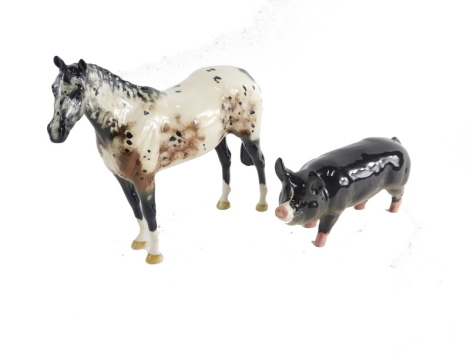 A Beswick pottery Appaloosa horse, standing, 21cm high, boxed, and a Beswick pottery pig. (2, AF)