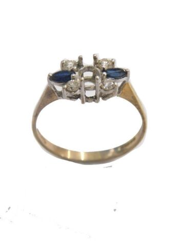 A 9ct gold dress ring, with vacant centre, flanked by two small blue sapphires, size O, 1.6g all in.